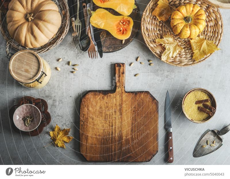 Food background with pumpkins, cutting board, knife and other spices and ingredients, top view. Frame. Seasonal autumn cooking concept food background frame
