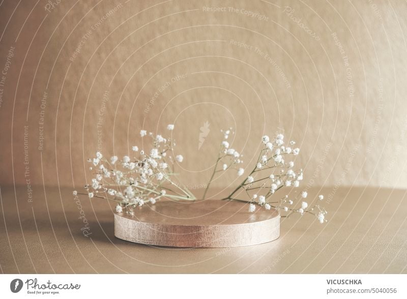 Beige product display with podium and little white gypsophila flowers. Scene stage showcase. Front view with copy space. beige scene front view abstract beauty
