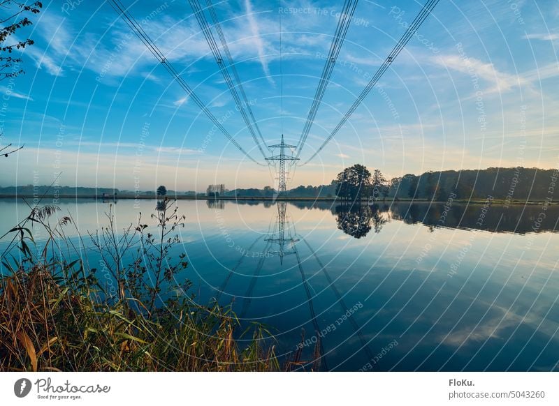 Power pole over lake Electricity pylon Lake reflection power line Energy industry High voltage power line Sky Technology stream Power transmission high voltage