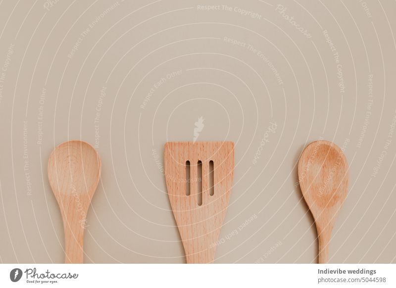 Three different wooden spoon on beige paper background. Copy space, flat lay photo. isolated brown copy space cooking tool kitchenware spatula utensils