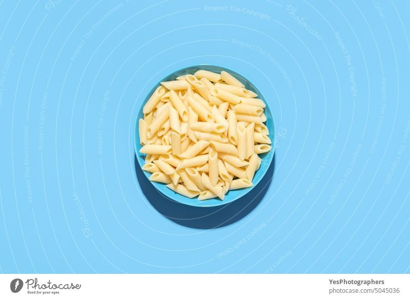 Penne pasta top view isolated on a blue background above bowl bright carbs classic color cooked copy space creative cuisine cut out delicious diet dinner dish