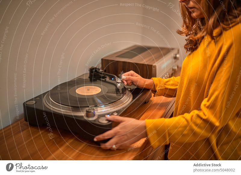 Crop person playing music on vintage record player turntable woman stylus retro vinyl sound old fashioned meloman device listen design equipment hobby female