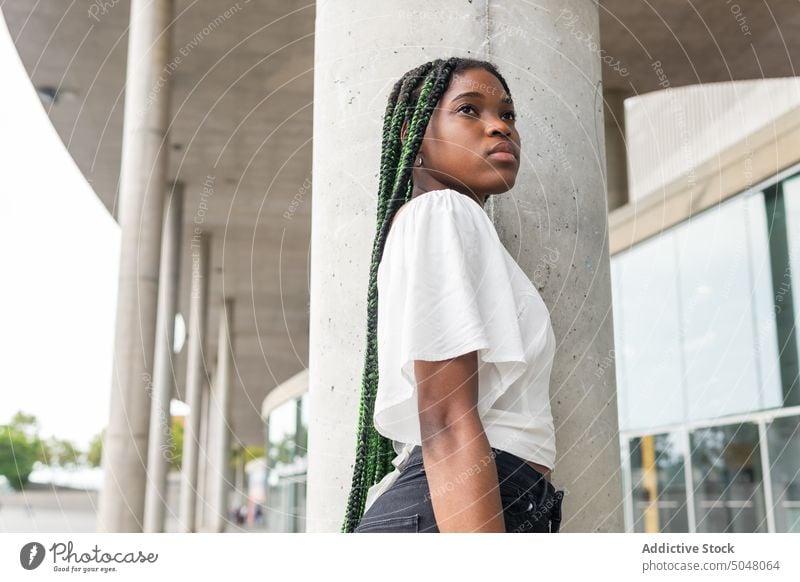 Cool young black female with long braids woman confident modern hairstyle street style contemporary individuality urban cool trendy appearance ethnic long hair