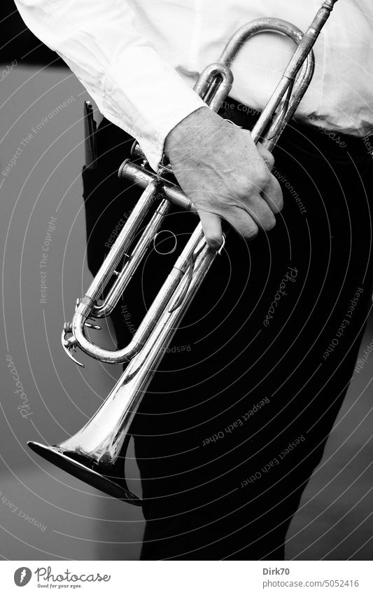 Trumpet held in hand by man with black pants and white shirt Trumpeter Brass band music wind instrument Wind instrument Man Music Musician Black & white photo