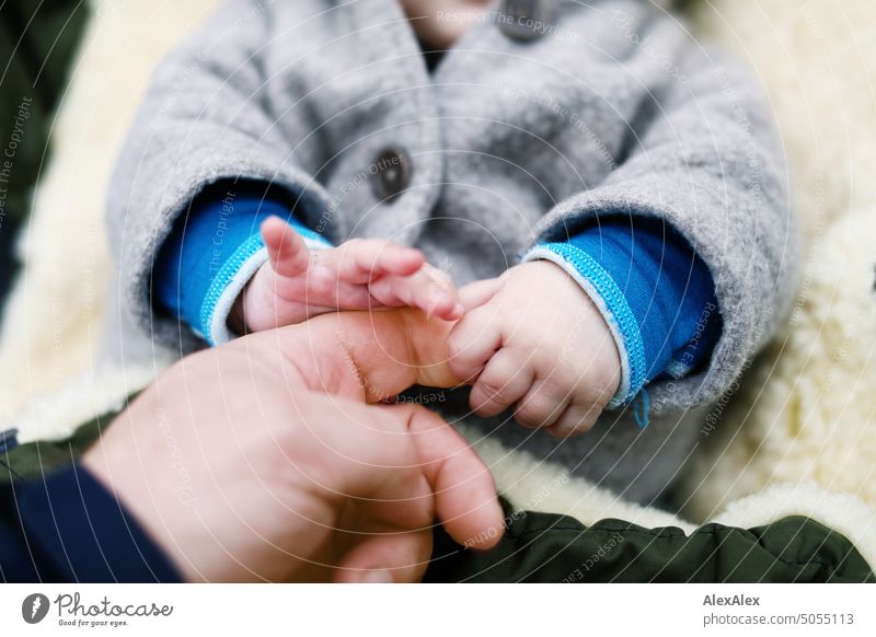 Two small baby hands grasp the index finger of an adult. Fingers Forefinger Hand Toddler Baby Cute clumsy youthful Very young Boy (child) Man Men`s hand