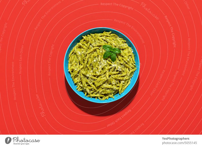 Pasta with pesto sauce, top view on a red background above basil bowl bright carbs cheese classic color copy space creative cuisine cut out delicious dinner