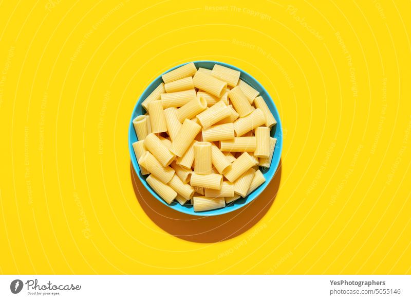 Rigatoni pasta top view on a yellow background above bowl bright carbs color cooking copy space creative cuisine cut out delicious dinner food gourmet homemade