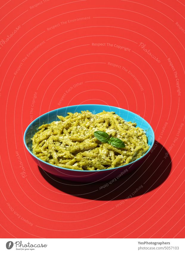 Pasta with pesto minimalist on a red background above basil bowl bright carbs cheese classic color copy space creative cuisine cut out delicious dinner dish