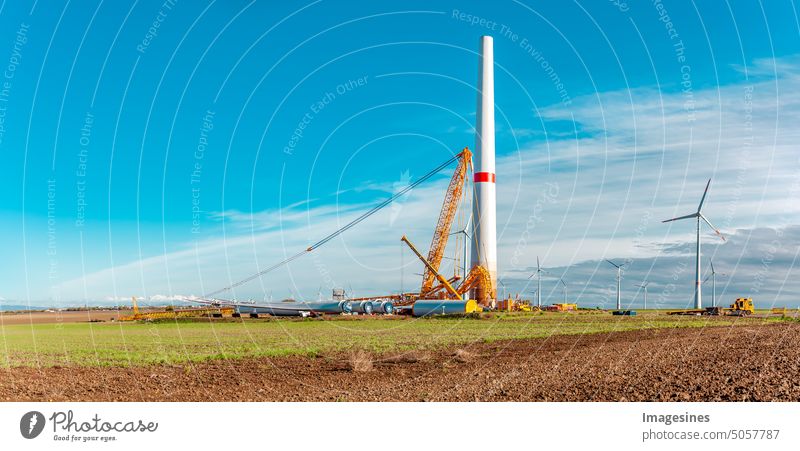 Construction site. Erection and assembly of a wind turbine by crane. Construction work at the wind turbine in Wörrstadt wind farm, Germany. Energy crisis concept, wind turbine construction