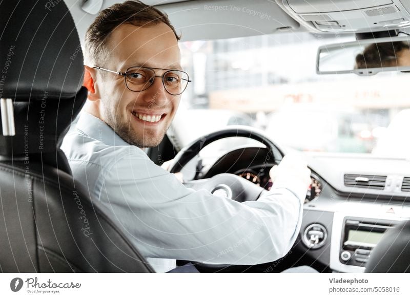 Portrait of smiling man in his car. Business taxi driver. Looking camera. saloon view vehicle automobile male cab glasses shirt adult happy business person