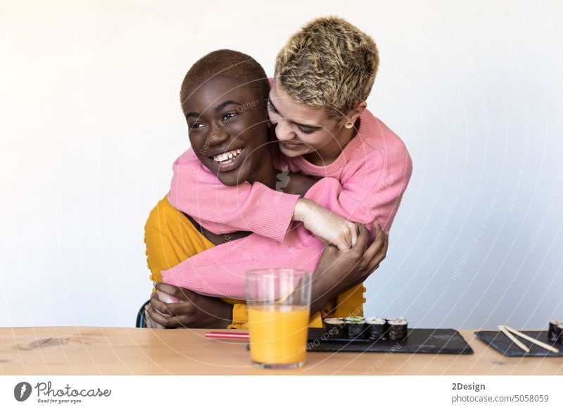 oung female hugging each other in a close embrace while laughing and smiling, affection affectionate african african american embracing enjoying friend