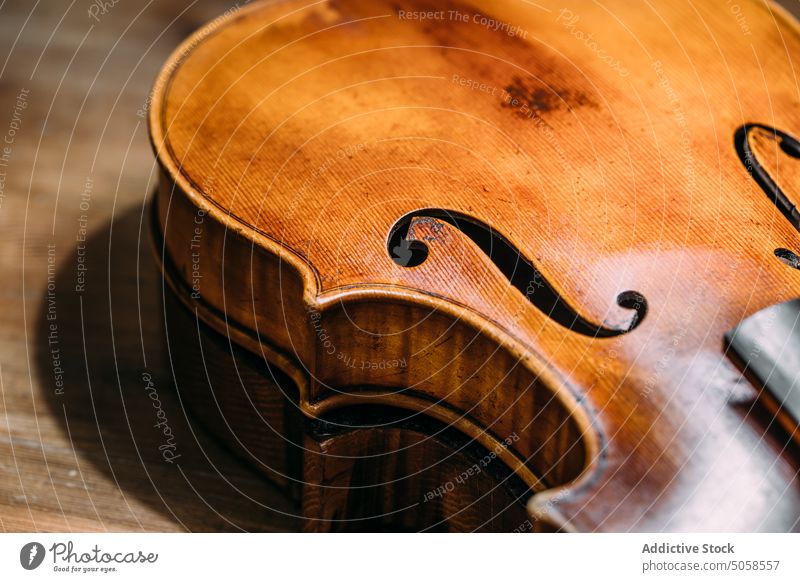 Hand crafted wooden violin on workbench workshop instrument luthiery table artisan shiny maker production handicraft manufacture professional handmade polished