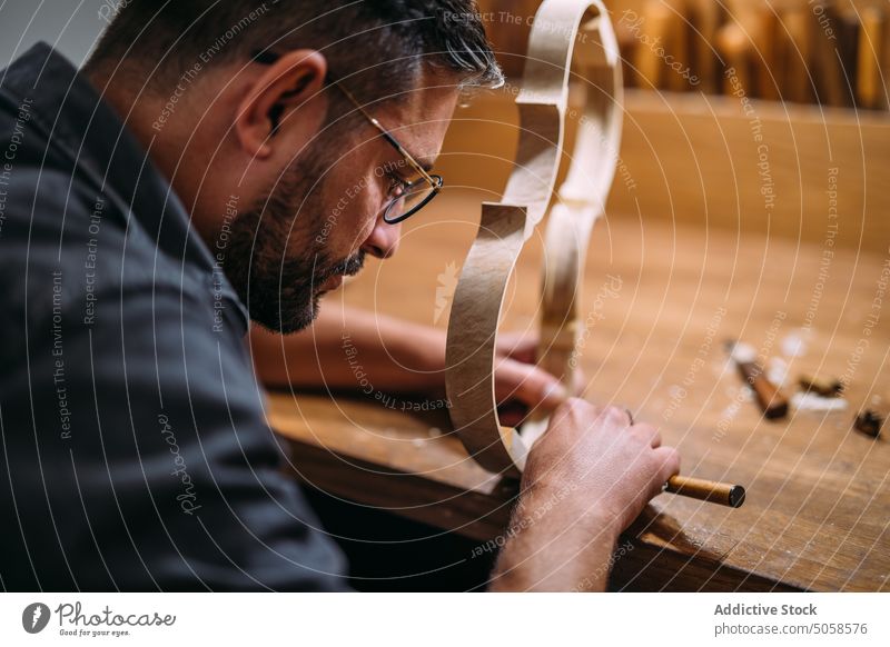 Luthier creating violin ribs in workshop craftsman artisan instrument professional workbench skill production handmade manual manufacture process master precise