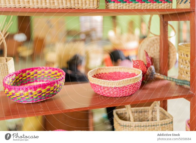 Wicker baskets on shelf in workshop bowl handmade colorful dry grass wicker creative natural design basketry craft manufacture handicraft bright production