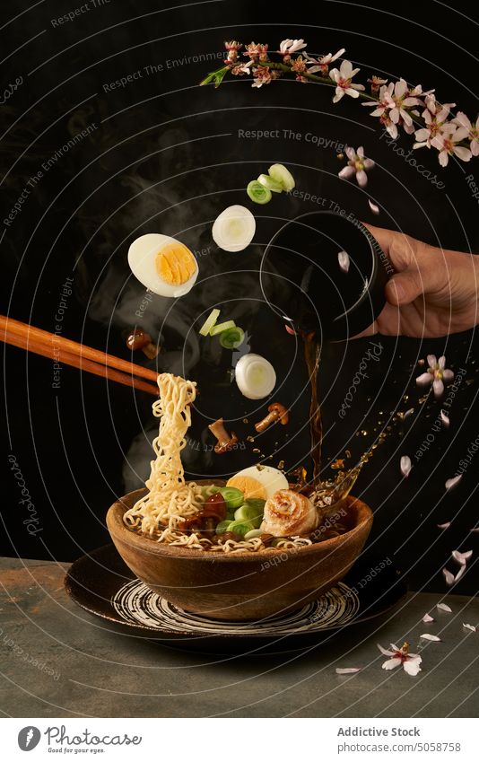Chef pouring miso broth into bowl with ramen in studio cook soup chef culinary asian food egg mushroom ingredient japanese recipe fall onion prepare sauce add