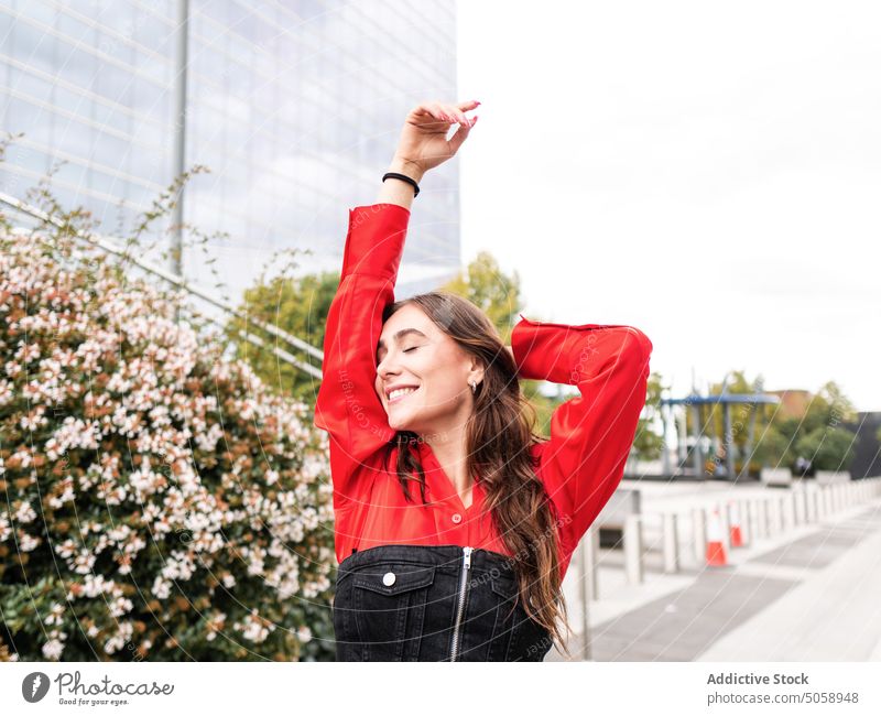 Cheerful young woman on street smile happy style spring urban outfit weekend candid female merry eyes closed carefree touch head excited personality cheerful