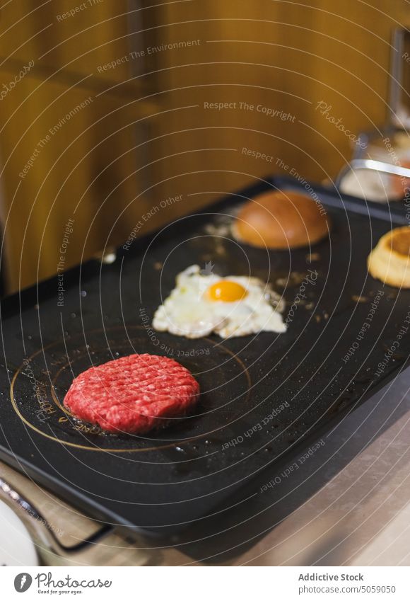 Burger on electric grill steak cook fry kitchen ingredient burger process delicious food culinary cheese bacon bun egg meal hamburger tasty appetizing product