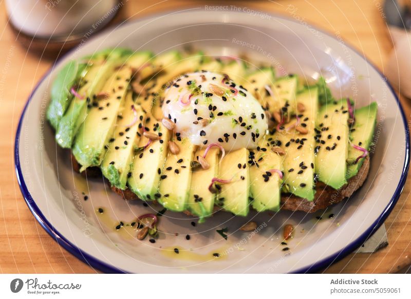 Delicious toast with avocado and poached egg food serve breakfast meal healthy food chia appetizing tasty seed delicious ceramic yummy table fresh dish gourmet