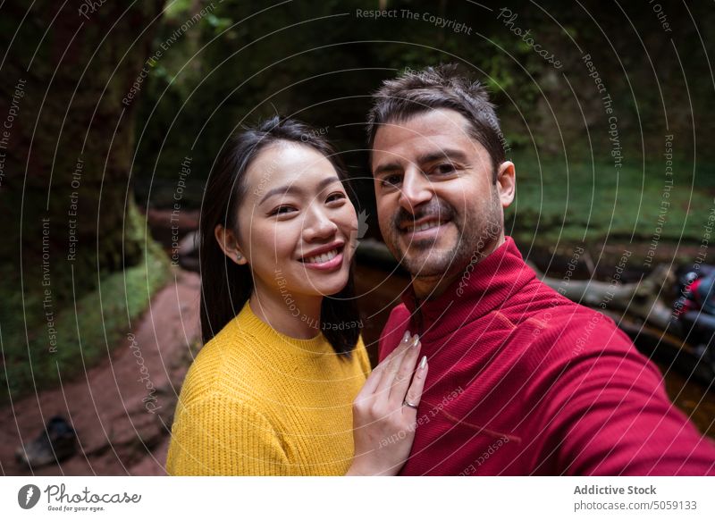 Happy diverse couple taking selfie in park smile boyfriend girlfriend cheerful forest travel vacation scotland nature happy together relationship asian memory