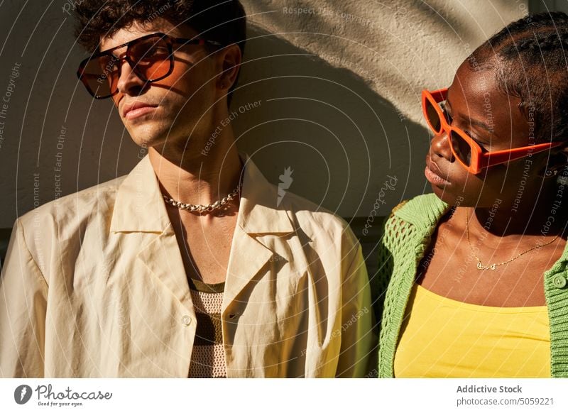 Stylish diverse couple looking away on street in daylight spend time relationship trendy style glamour together soulmate partner wall summer gorgeous sunglasses