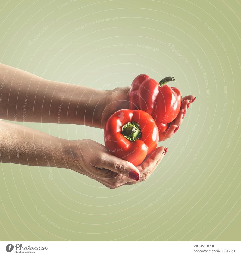 Women hands holding red paprika at green background. women bell pepper closeup vitamin object healthy vegetable vegetarian organic food