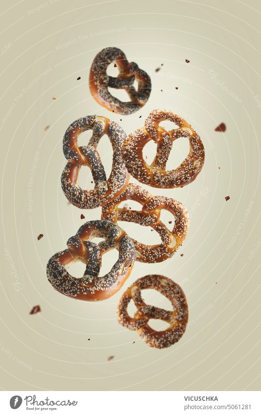 Flying pretzel at beige background. Traditional German food flying traditional german food objects salty bavarian bakery bread buns delicious germany junk