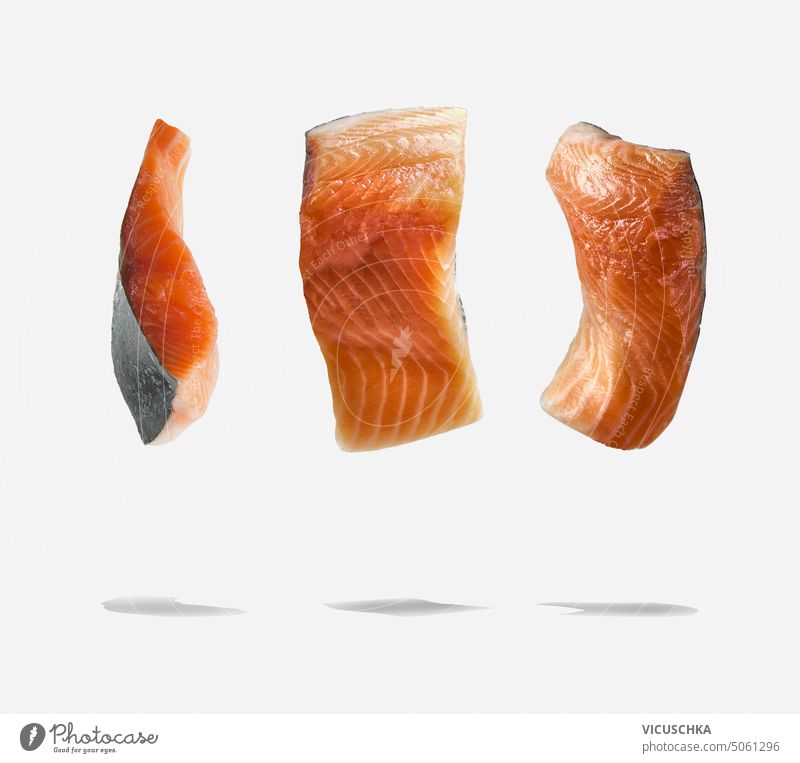Raw flying salmon fish fillet with shadow at white background. Food levitation raw food object diet fresh healthy ingredient seafood