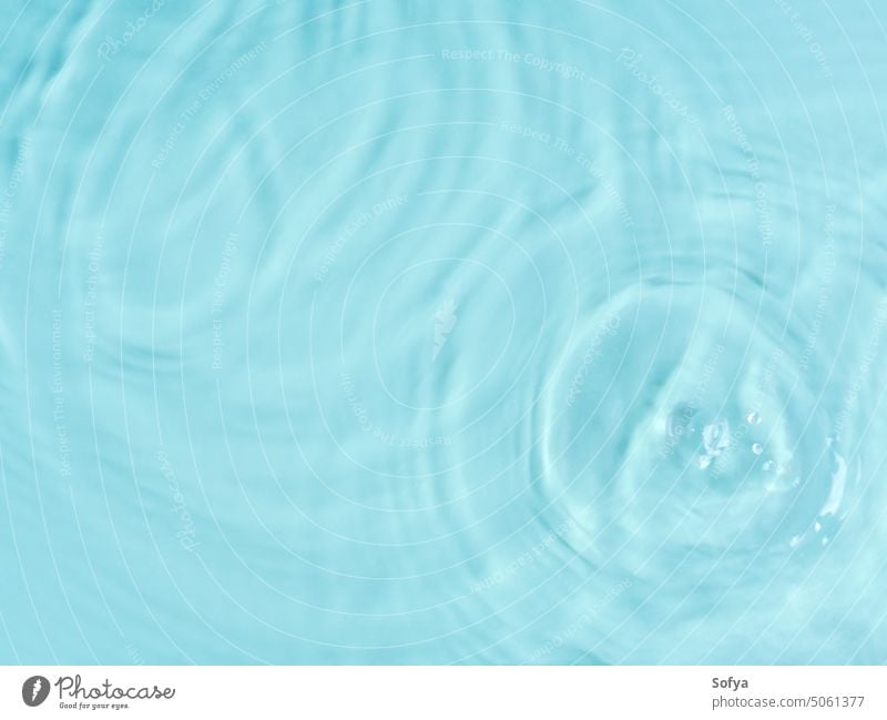 Blue water surface color background with ripples, circles and drops beach spa design abstract teal green summer wave texture nature banner sun art clean liquid