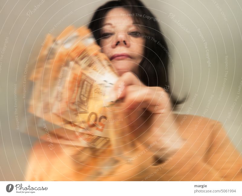 A woman holds many banknotes in her hands Woman Face of a woman Adults Money Bank note Euro 50 euros 50 Euro notes Loose change Income Luxury Paying Save