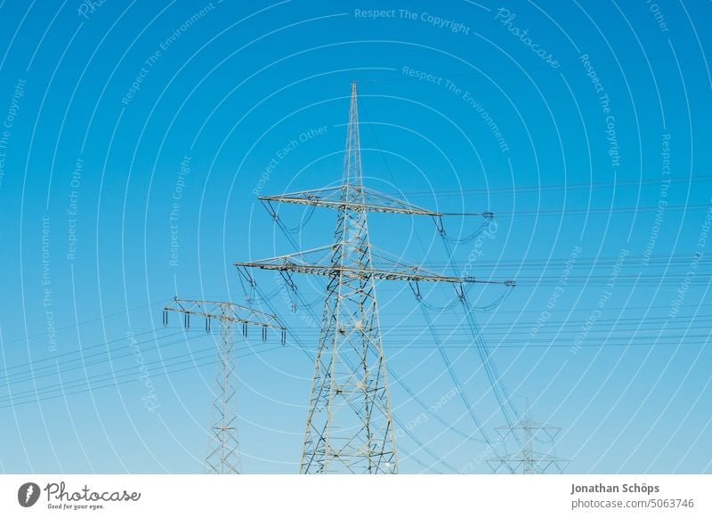 high energy cost, power pole on field against blue sky energy cost increase Electricity pylon stream power line Energy crisis Renewable energy Field Landscape