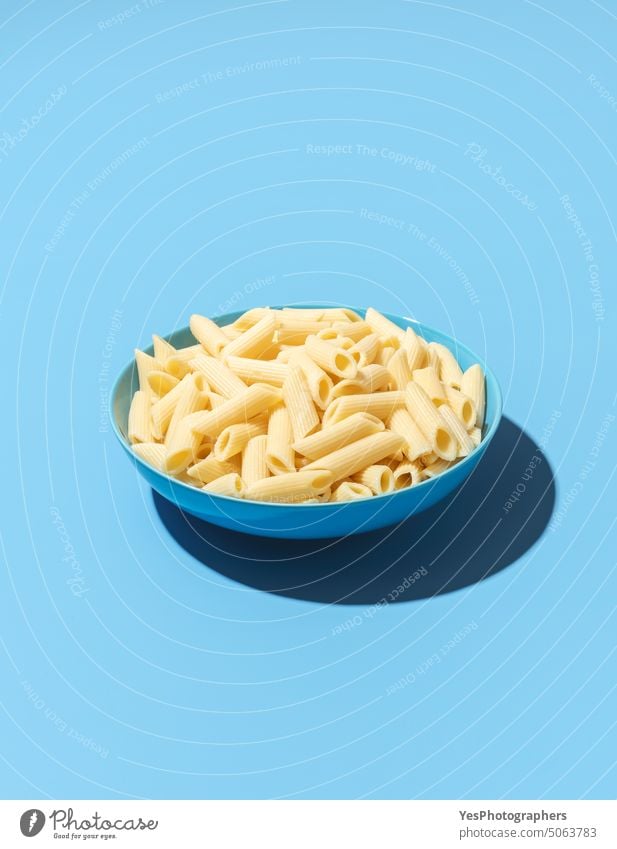 Penne pasta bowl minimalist on a blue background above bright carbs classic color cooked copy space creative cuisine cut out delicious diet dinner dish food