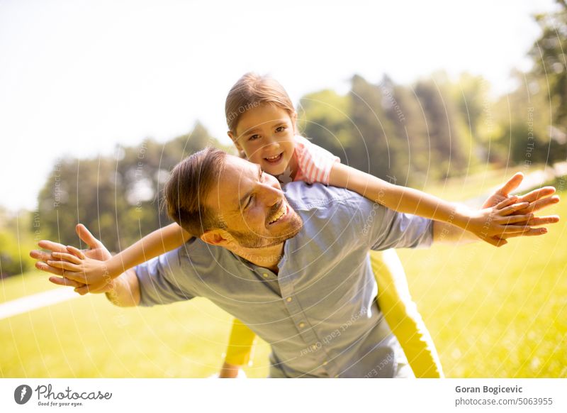 Father with daughter having fun at the park back beautiful beauty caucasian child childhood closeness dad day enjoying expressions exterior family father