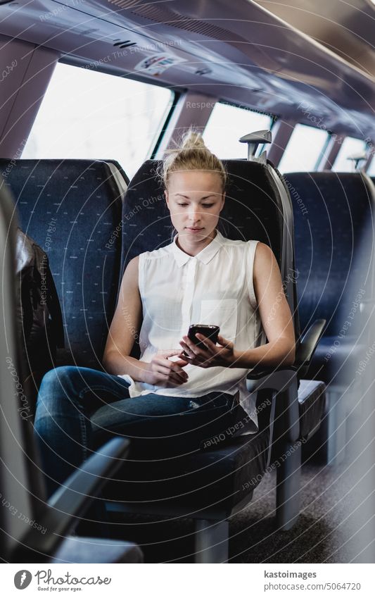Woman using mobile phone while travelling by train. woman talk transport passenger railway journey business transportation smart phone cell phone commuter