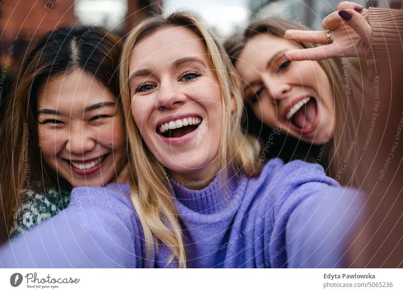 Three girlfriends having fun taking a selfie real people candid woman girls young adult friendship girl power city urban city life youth millennials