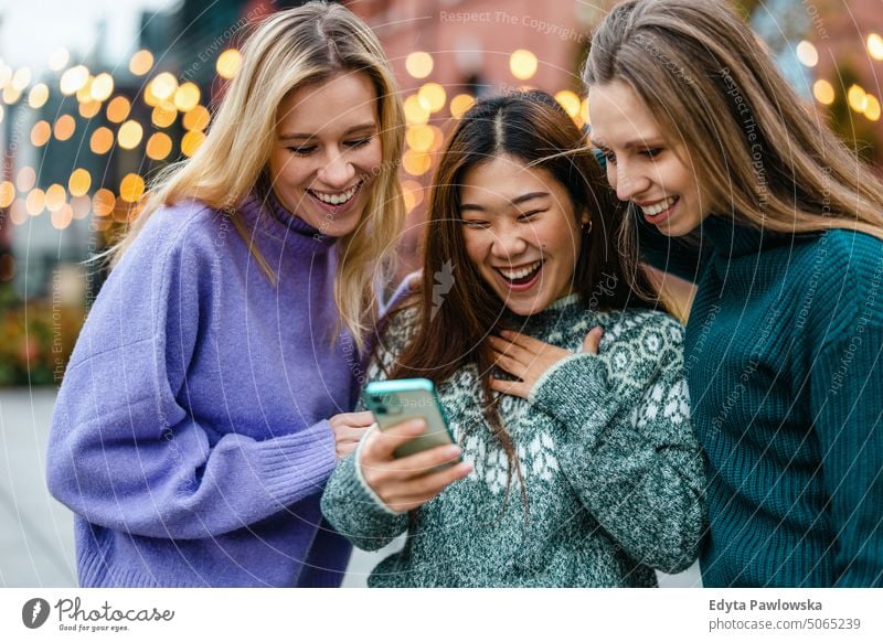 Group of friends in the street with smartphone real people candid woman girls young adult friendship girlfriends girl power fun city urban city life youth