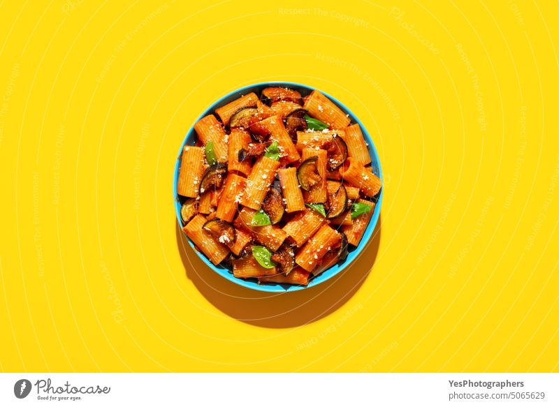 Pasta with eggplant top view on yellow background above basil bowl bright carbs color cooking copy space creative cuisine cut out deep-fried delicious dinner
