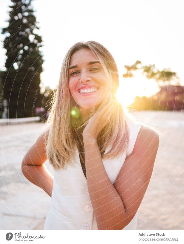 Optimistic female touching neck at sunset woman park smile weekend summer happy evening touch neck appearance young sunshine blond cheerful dusk twilight
