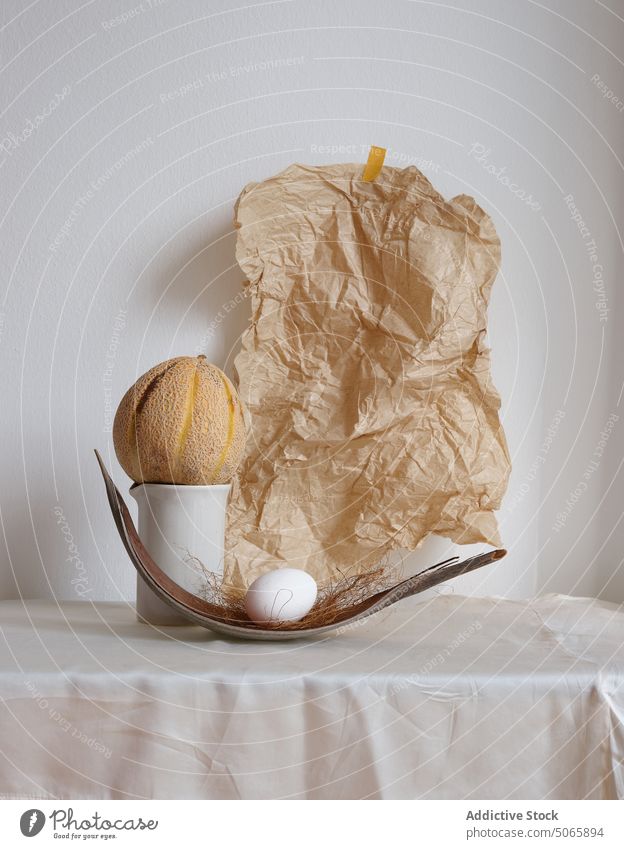 Composition with a melon and an egg fruit still life organic natural art design texture nature paper wrinkled folded textile fabric lifestyle object arrangement