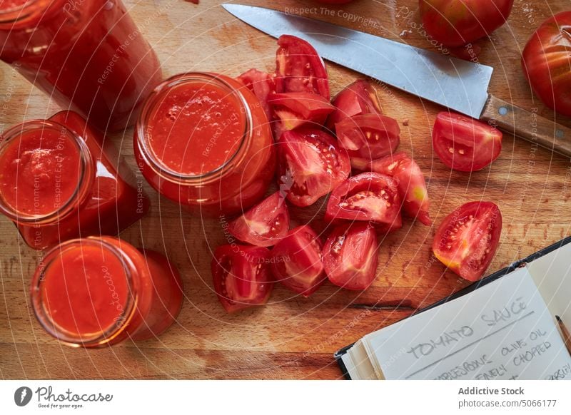 Tomatoes and sauce near recipe tomato notebook homemade jar ingredient table kitchen food vegetable delicious tasty fresh ripe vegan nutrition gourmet vitamin