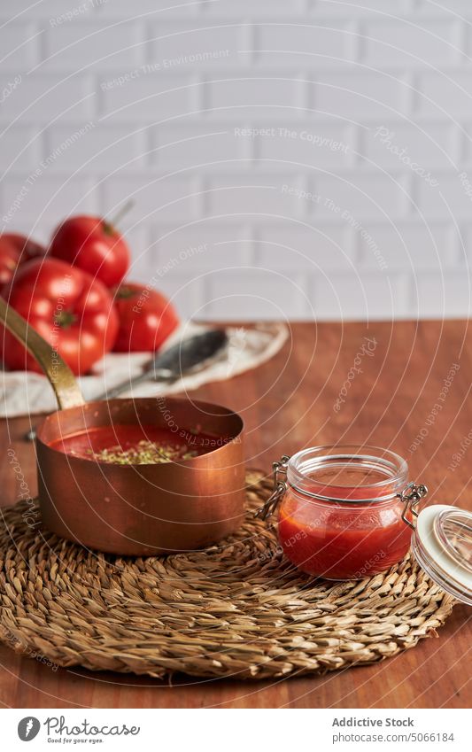 Container and pan with tomato sauce on table container composition homemade woven kitchen saucepan jar bowl spoon nutrition culinary tasty ingredient wooden