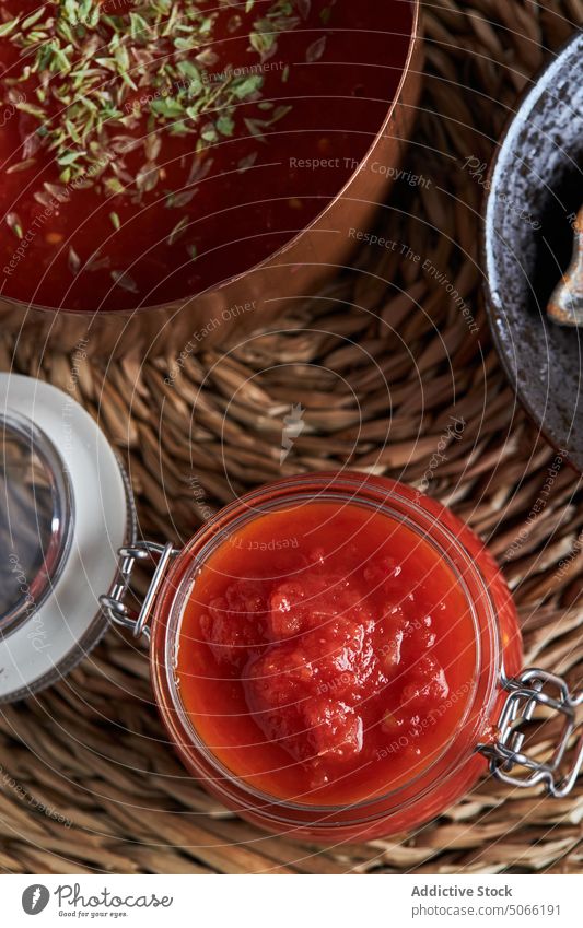 Container and pan with tomato sauce on table container sprinkle composition homemade woven oregano kitchen saucepan jar bowl spoon nutrition culinary tasty