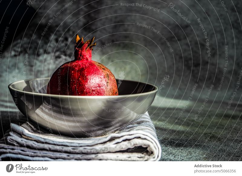 Ripe organic pomegranate fruit background ceramic concept dessert diet eat food grey healthy modern napkin concrete nature bowl plate red ripe rustic seed table