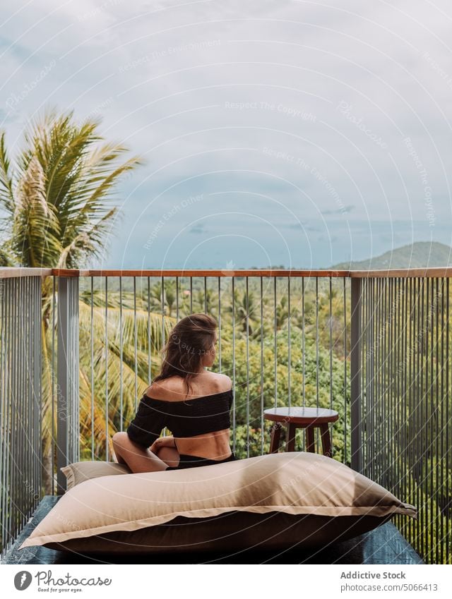 Woman on balcony viewing tropical nature woman resort rest summer vacation lush hotel greenery admire tourist recreation terrace traveler exotic mountain relax
