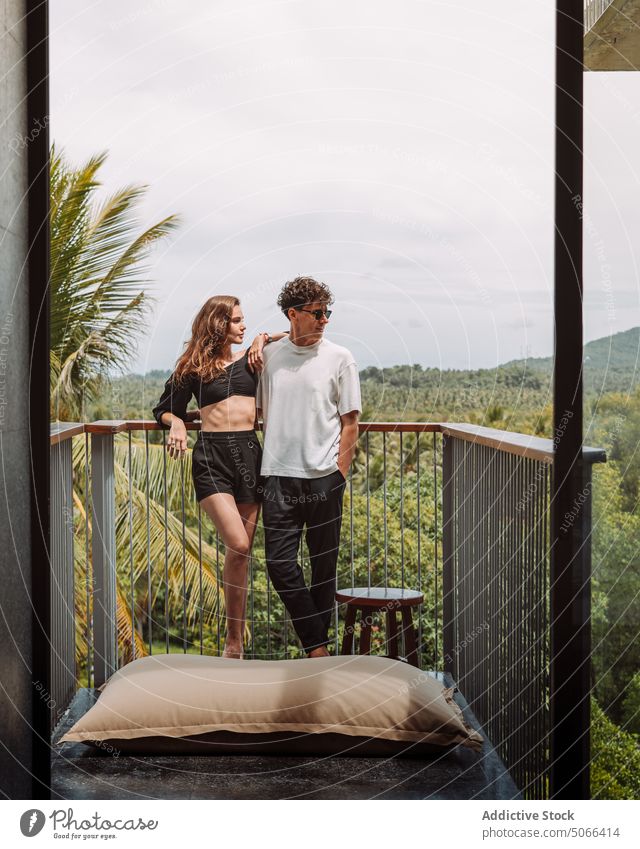 Couple resting on terrace of tropical resort couple vacation hotel balcony chill travel summer holiday enjoy relax together exotic boyfriend girlfriend