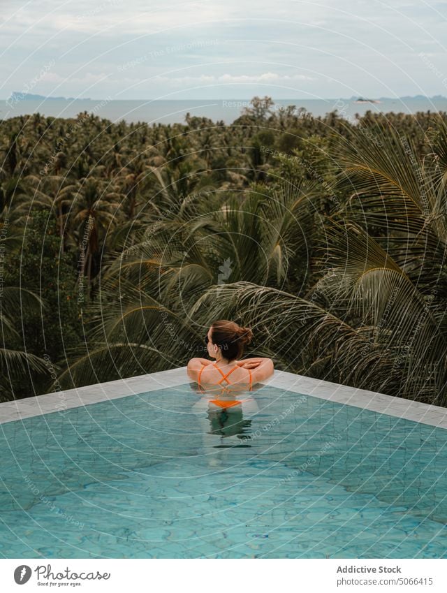 Woman chilling in pool on tropical resort woman vacation tourist nature relax green rest holiday paradise tourism plant exotic summer hotel lush travel traveler