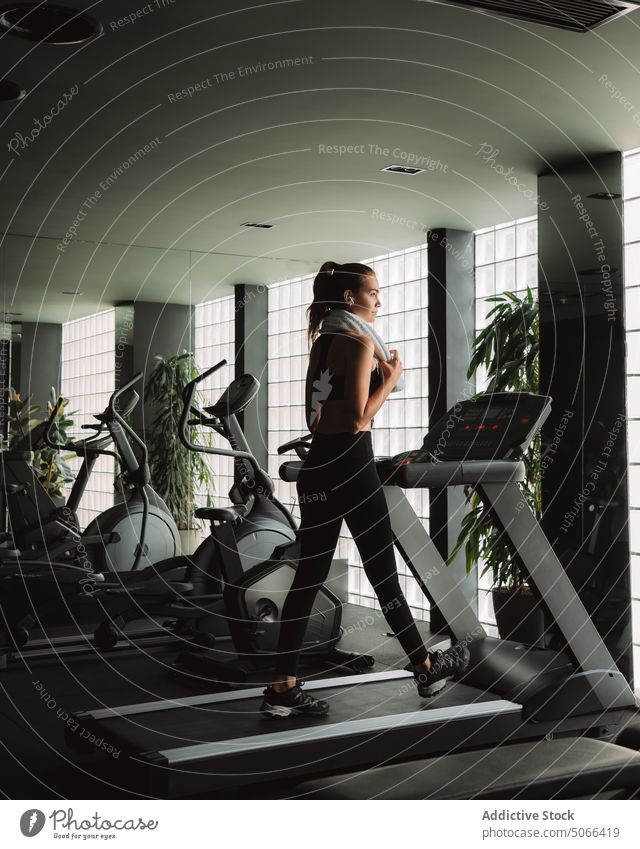 Woman on treadmill in modern gym woman exercise workout walk fitness warm up sport healthy training wellness wellbeing activity young physical active energy