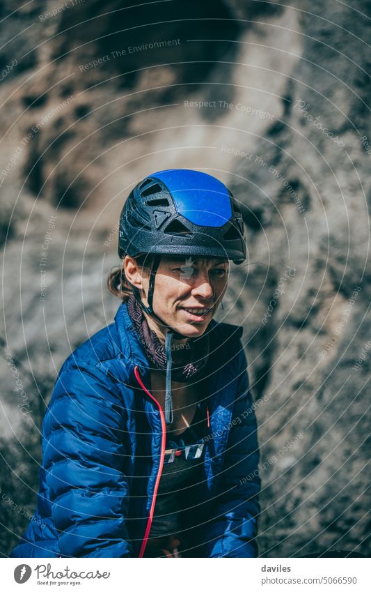Climber woman with blue helmet and jacket during a rest between climb journey active activity adventure andalusia athletic austrian break cliff climber climbing