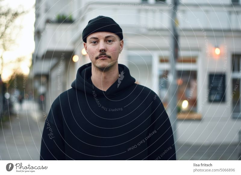 YOUNG MAN - WAITING - DAWN - Man 25-29 years Cap mustache Nose ring Adults Colour photo Exterior shot 20s Skeptical sad ponder patience Twilight clearer hoodie