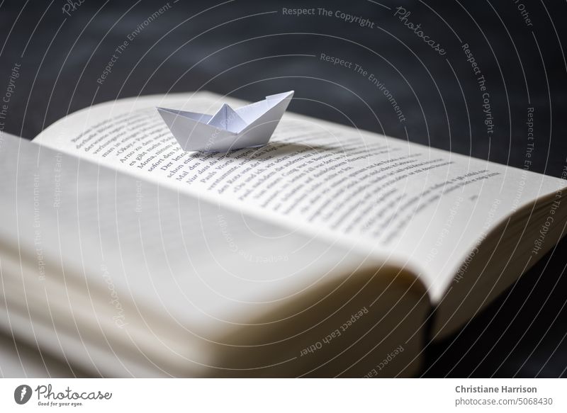 Paper boat on book page Book Reading Literature Education Study Library Novel books Reading matter browse at home Page To leaf (through a book)