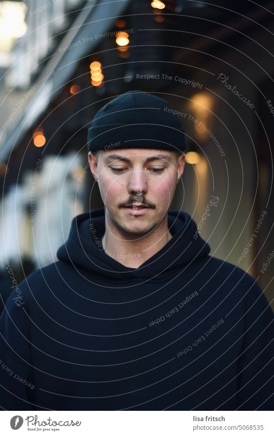 MAN - LOOK DOWN - LIGHTS Man hoodie Cap Fairy lights Adults Exterior shot Colour photo Downward Young man hip mustache Nose ring Life Habitat Lifestyle